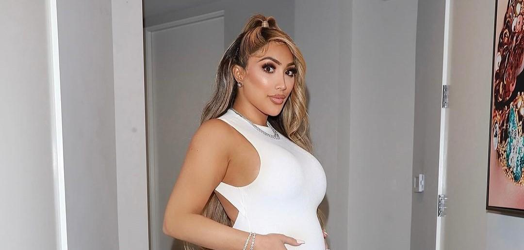 Miss Nikki Baby showing off her bump in a white jumpsuit