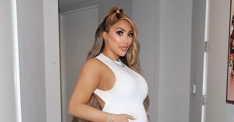 Miss Nikki Baby showing off her bump in a white jumpsuit