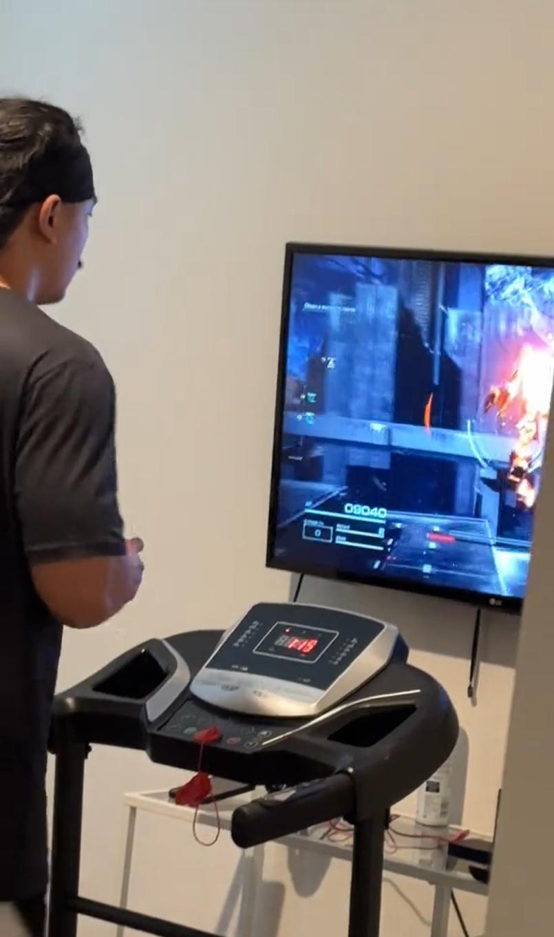 A person playing Armored Core 6 while on a treadmill.