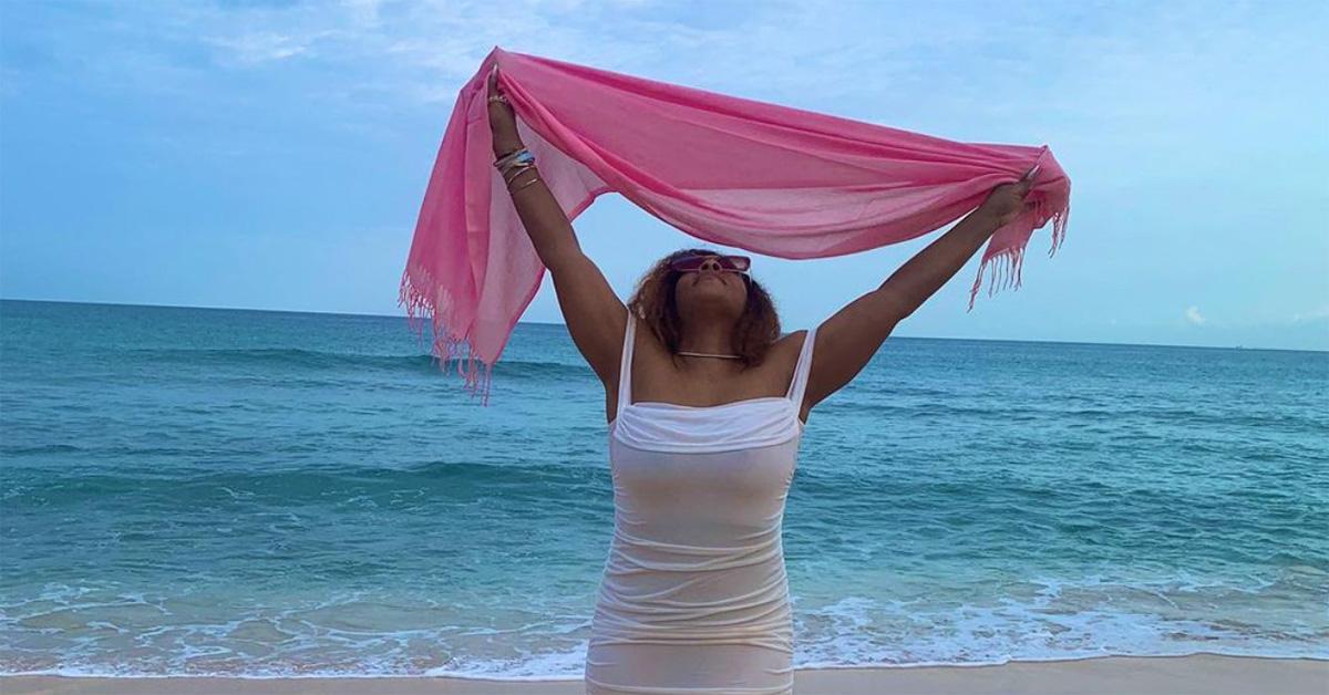 Marie Wright at the beach with her arms over her head. 