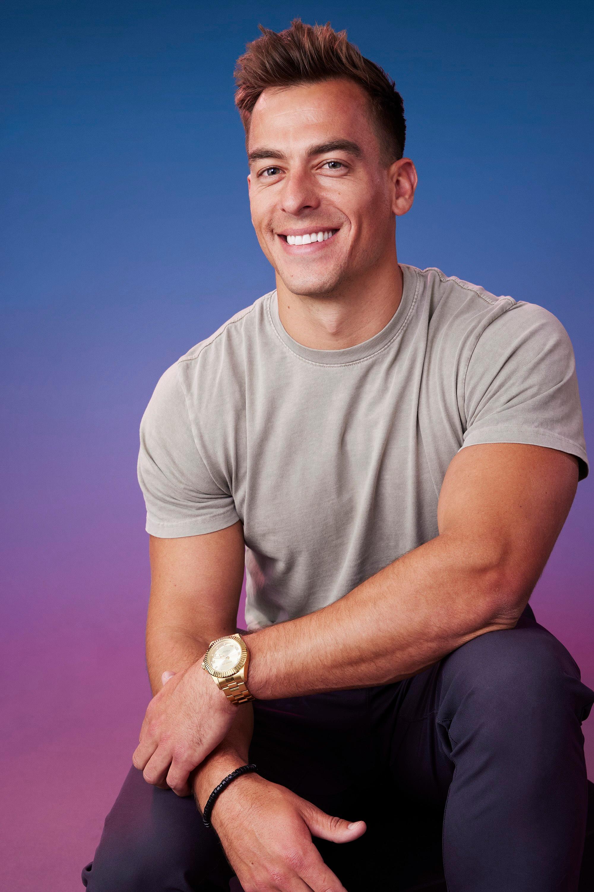 Aaron poses in front of a blue-purple ombré background for his official 'The Bachelorette' Season 21 portrait.