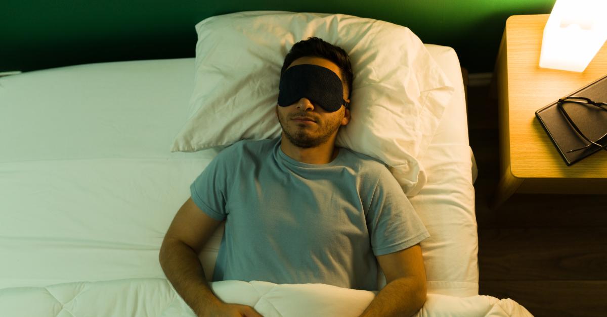 A man wears an eye mask while sleeping.