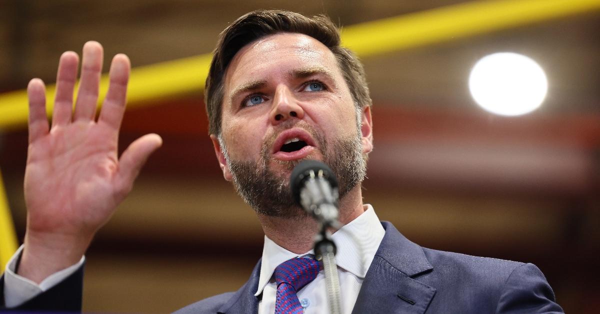 JD Vance waving, wearing purple tie