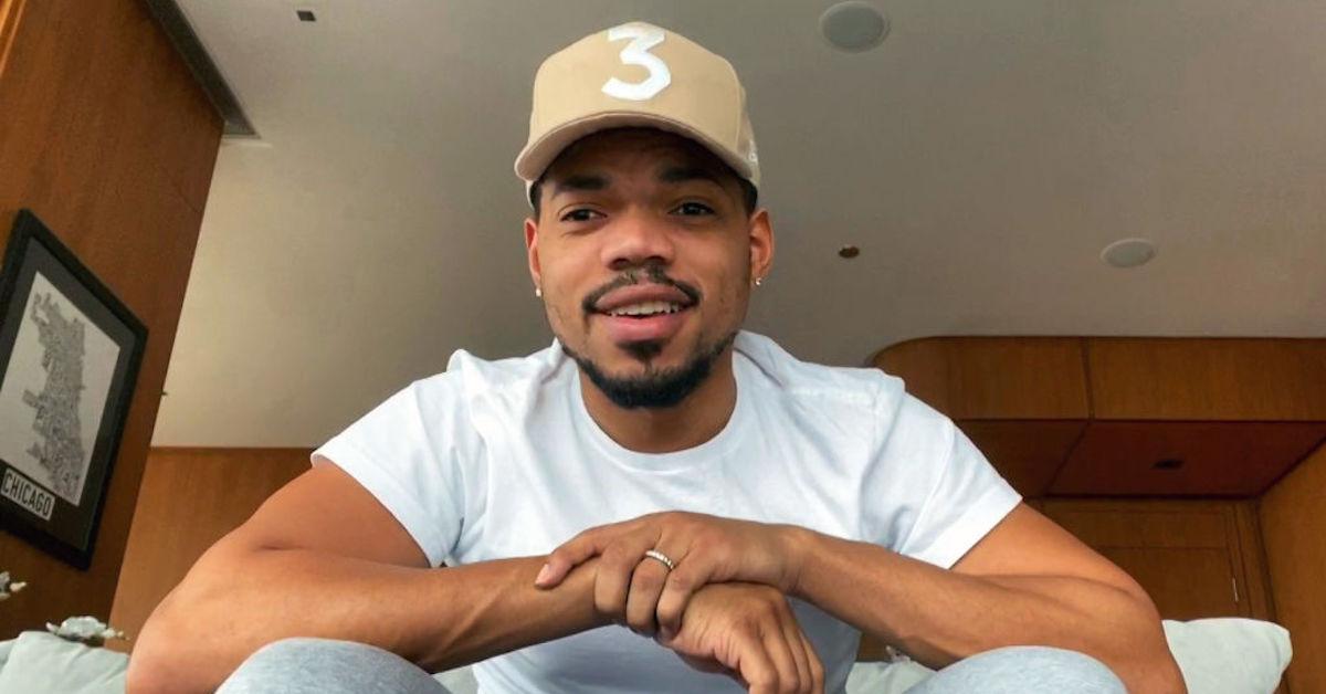 Chance the Rapper wearing a white shirt and a tan 3 hat