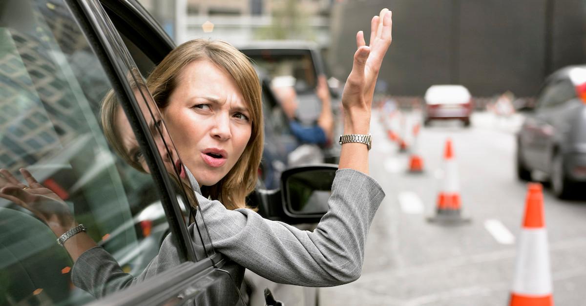 A woman with road rage leaning out of a car window