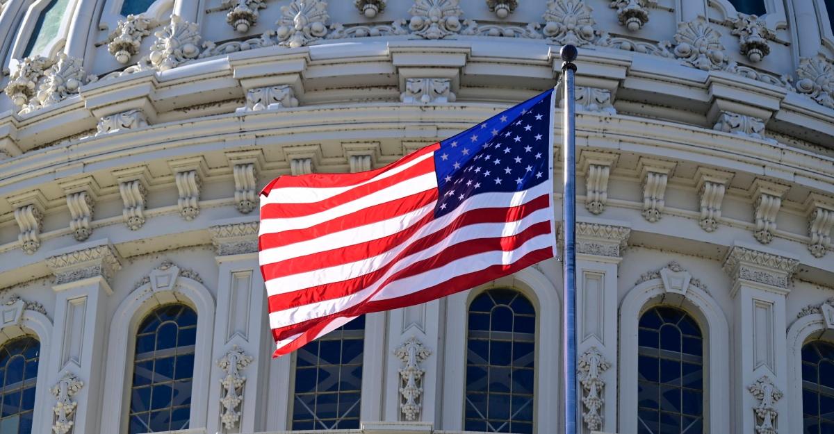 An American flag flies in front of the U.S. Capitol building
