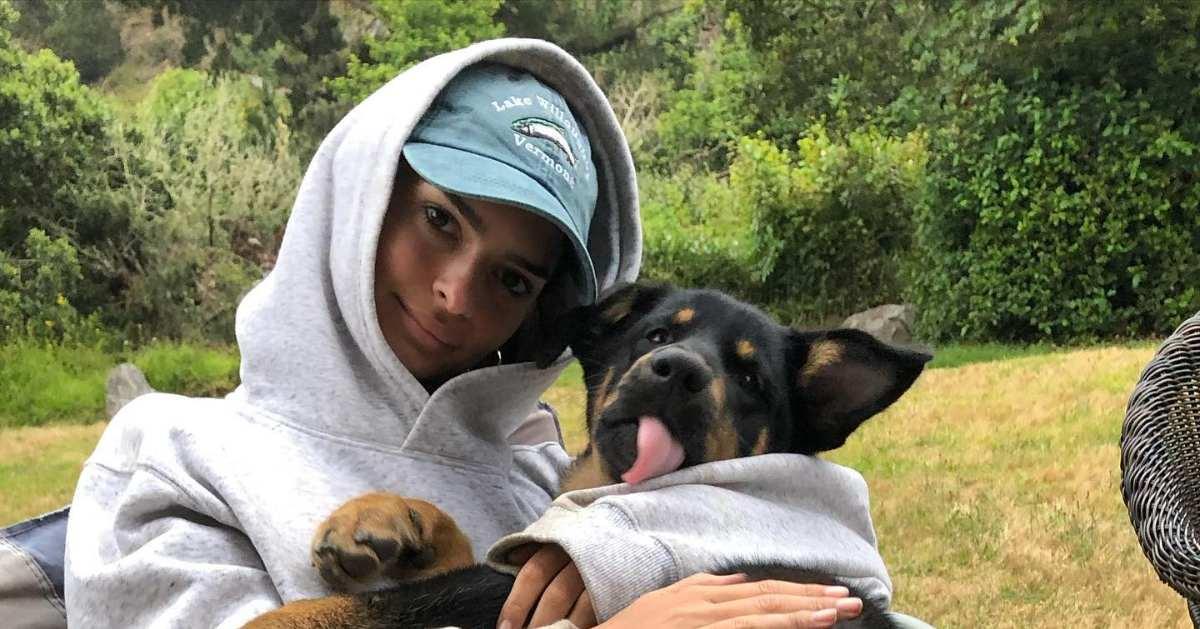 Emily Ratajkowski cuddling a dog in hoodie