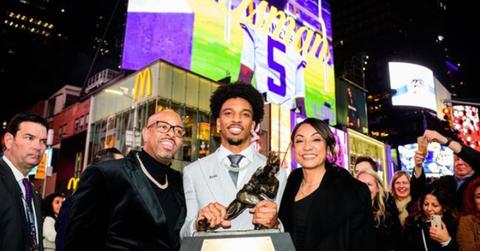 Jayden Daniels holding the Heisman Trophy with his parents
