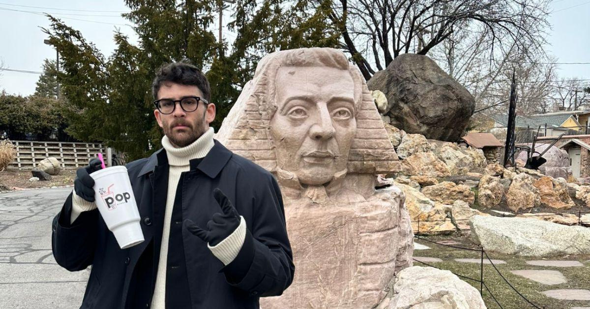 Hasan Piker in front of a sphynx-like statue in Utah. 