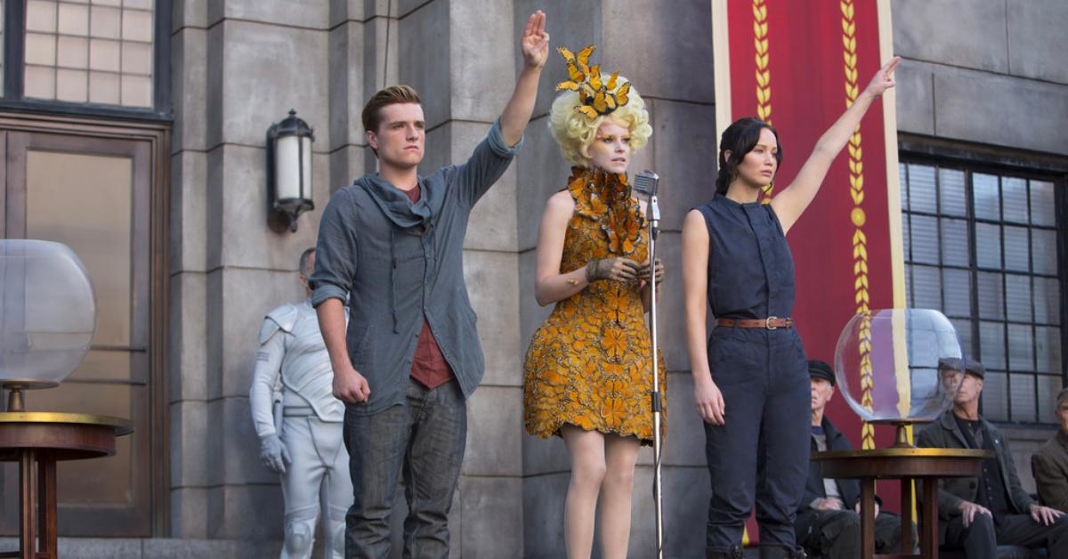 Peeta, Effie, and Katniss during District 12 reaping event in 'The Hunger Games: Catching Fire'