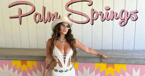Chanel West Coast in front of a Palm Springs sign