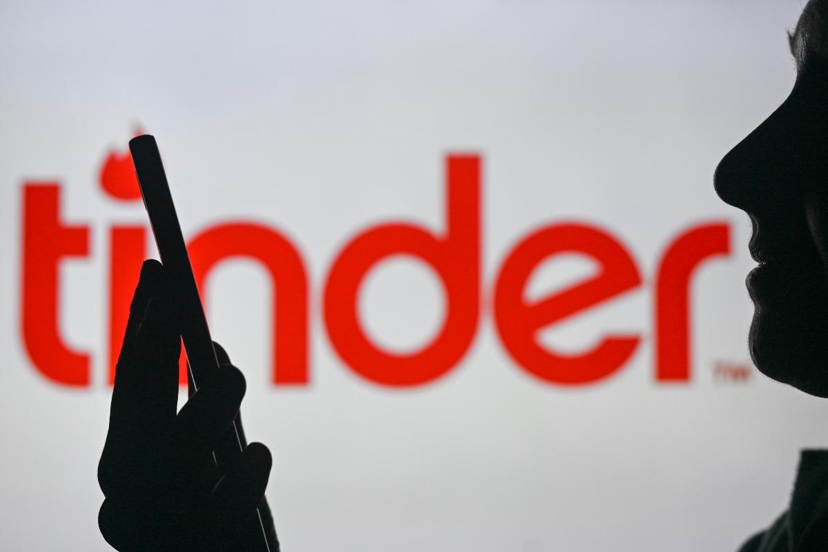 Tinder logo and someone looking at phone 