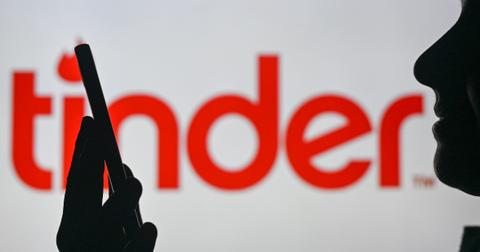 Tinder logo and someone looking at phone