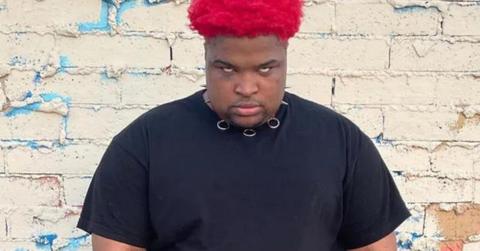 Mario Judah standing against a shabby brick wall