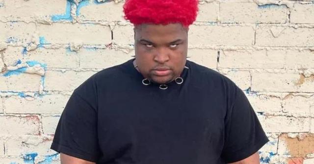 Mario Judah standing against a shabby brick wall