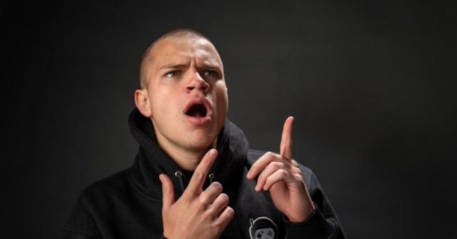Twitch streamer Jynxzi posing with his fingers up in a dark room.