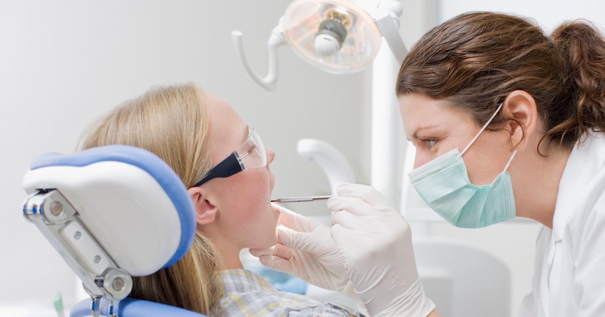 A dental hygienist looking in child's mouth