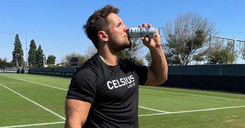 Nick Bosa drinking Celsius on a football field.