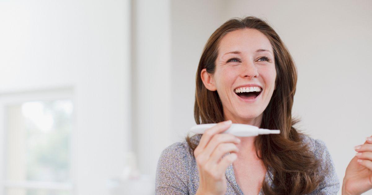 woman smiling pregnancy test