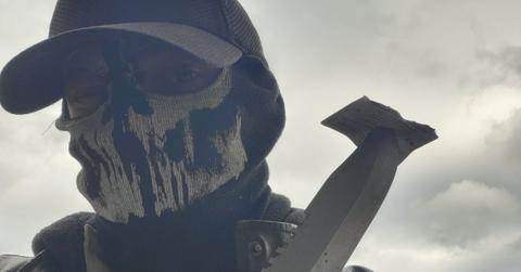 Shadman poses in his skull-like mask with a machete