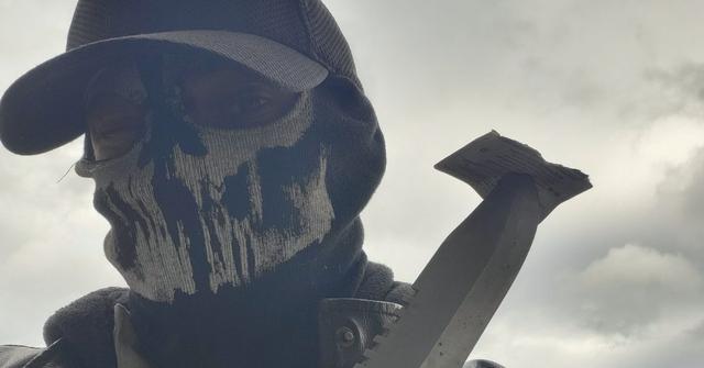 Shadman poses in his skull-like mask with a machete