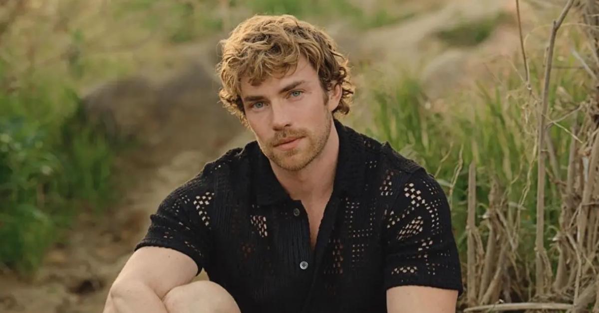 Zane Phillips sitting on the ground wearing a black shirt.