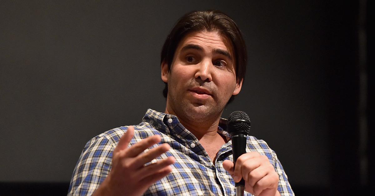 Kevin Turen in a flannel during a Q&A holding a microphone. 