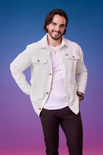 Tomas poses in front of a blue-purple ombré background for his official 'The Bachelorette' Season 21 portrait.