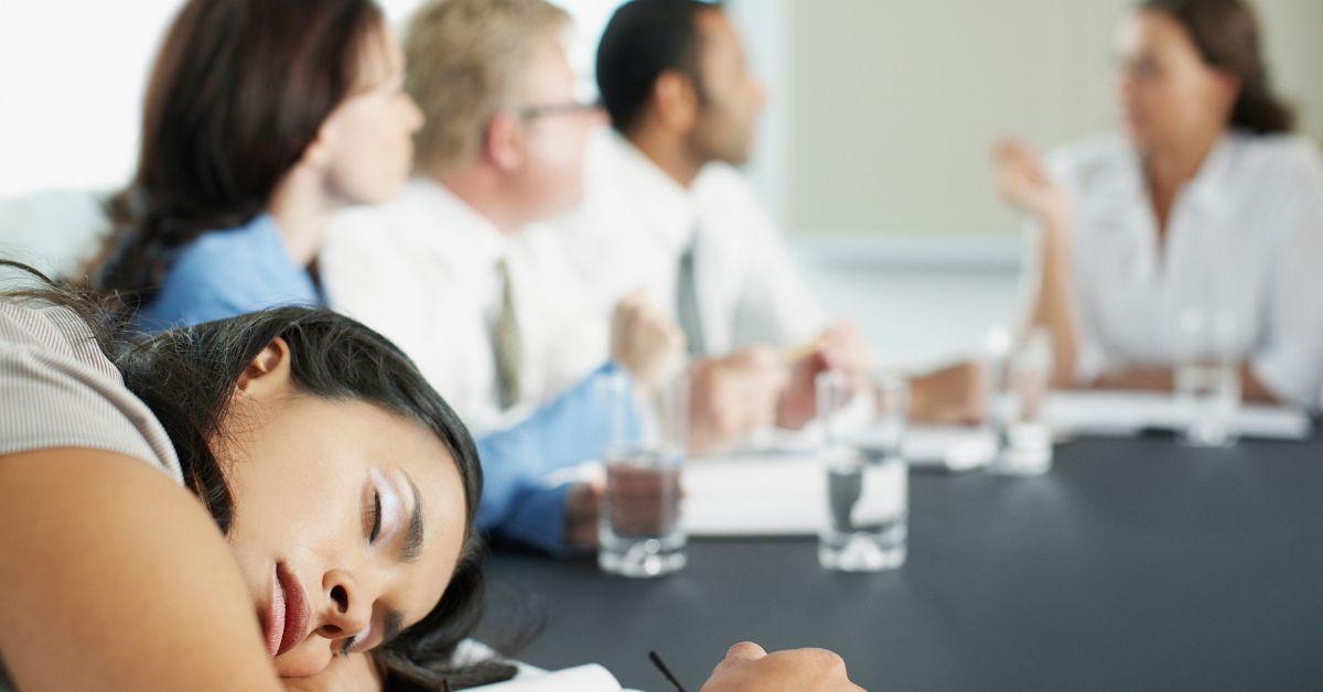 A woman sleeping at work during a meeting.