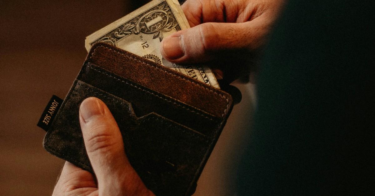 Someone pulling money out of their wallet