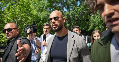 Andrew Tate surrounded by reporters