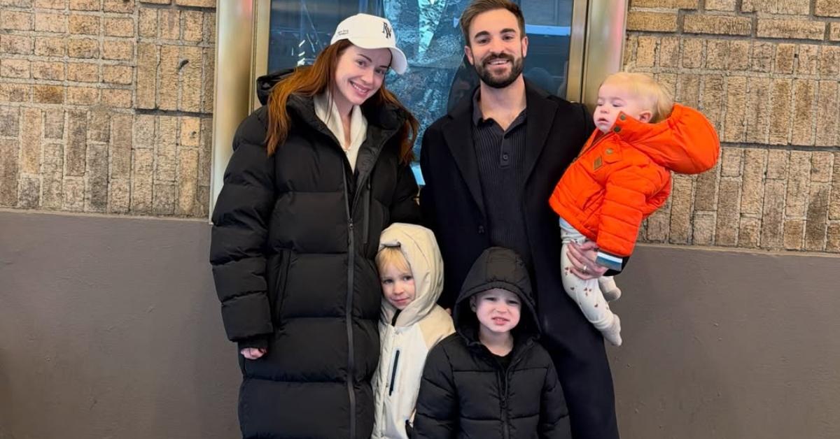 Whitney Leavitt and her family in front of a Chicago poster in New York City.