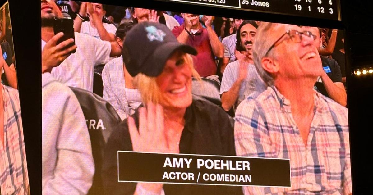 Amy Poehler and Joel Lovell are seen on a Jumbotron at a game,