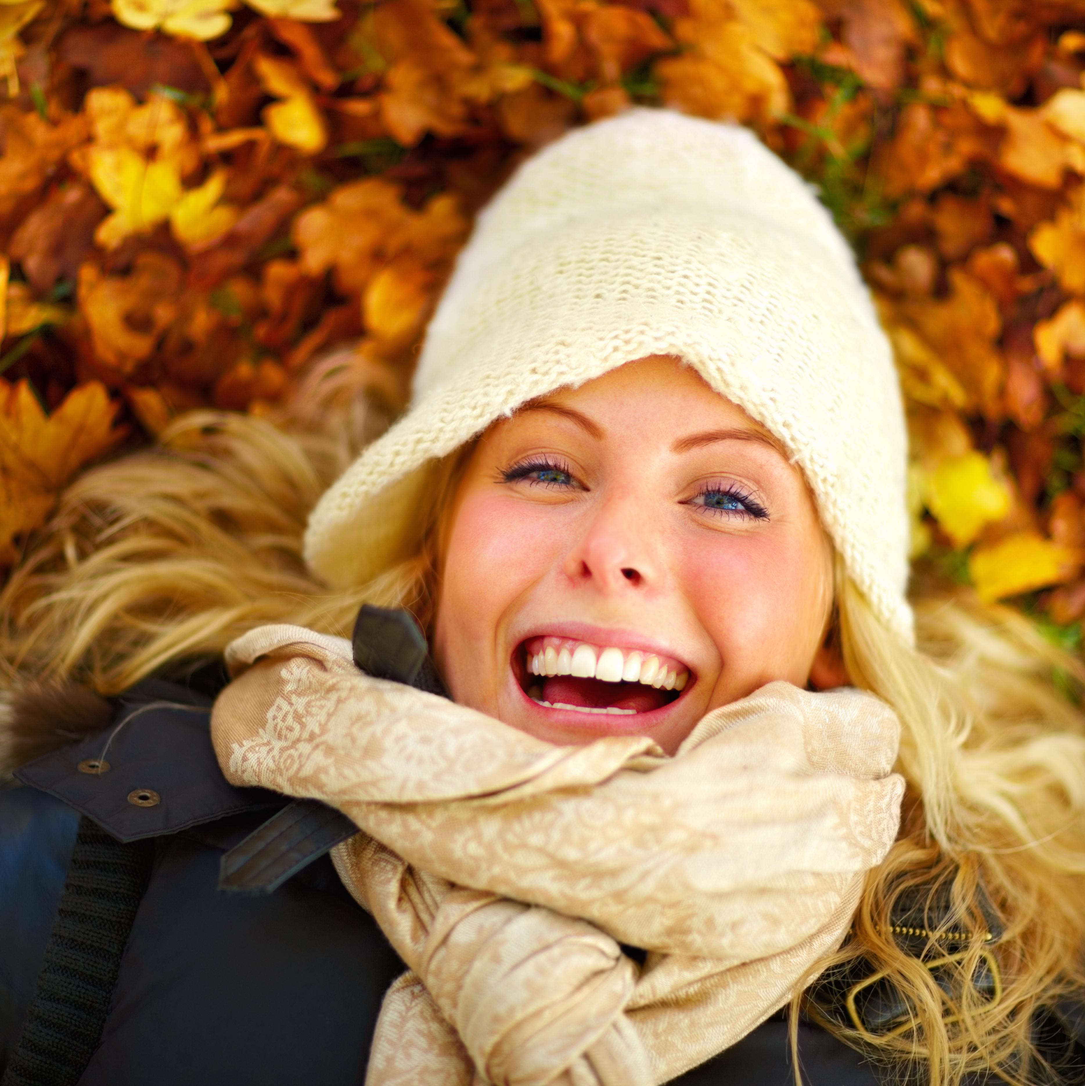 A girl laying in the leaves.