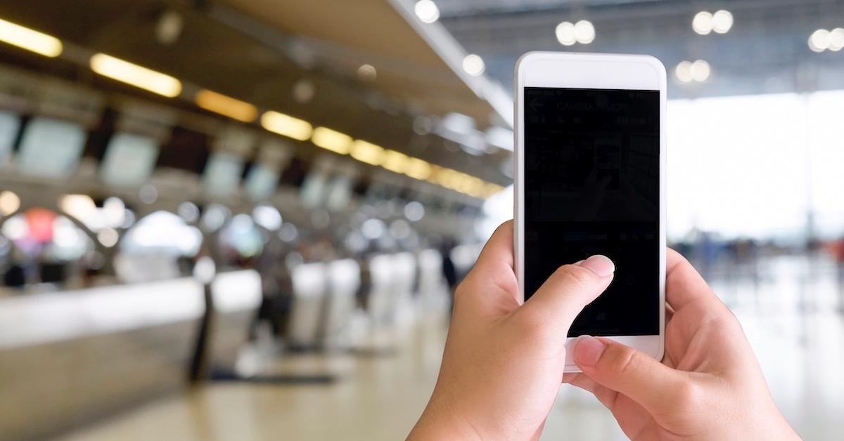 A person holding an iPhone in an airport