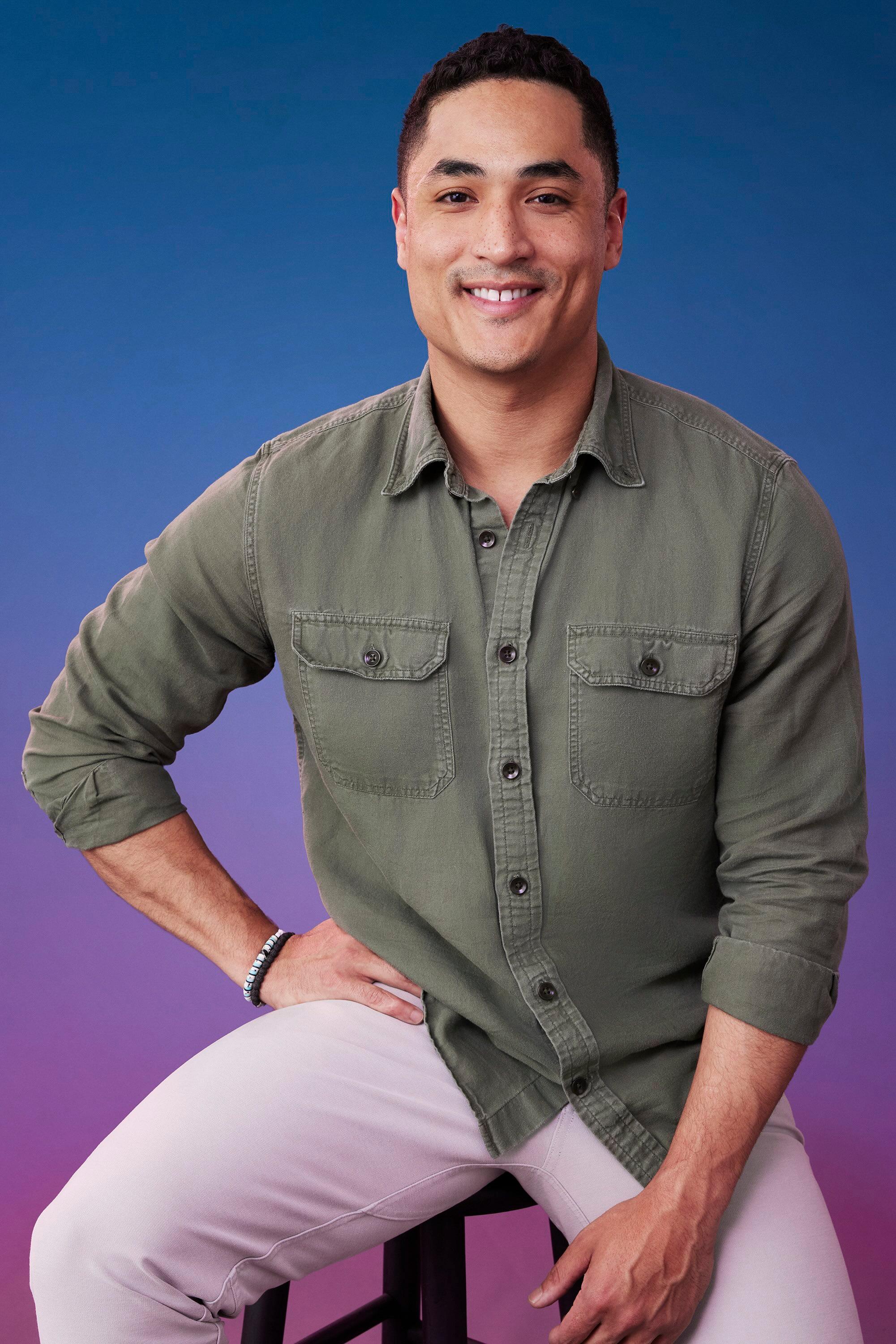 Marcus poses in front of a blue-purple ombré background for his official 'The Bachelorette' Season 21 portrait.