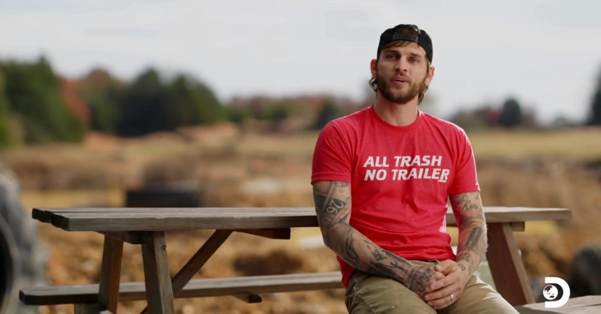 Bryce Sparks sits at a picnic table near a racing course on Mud Madness