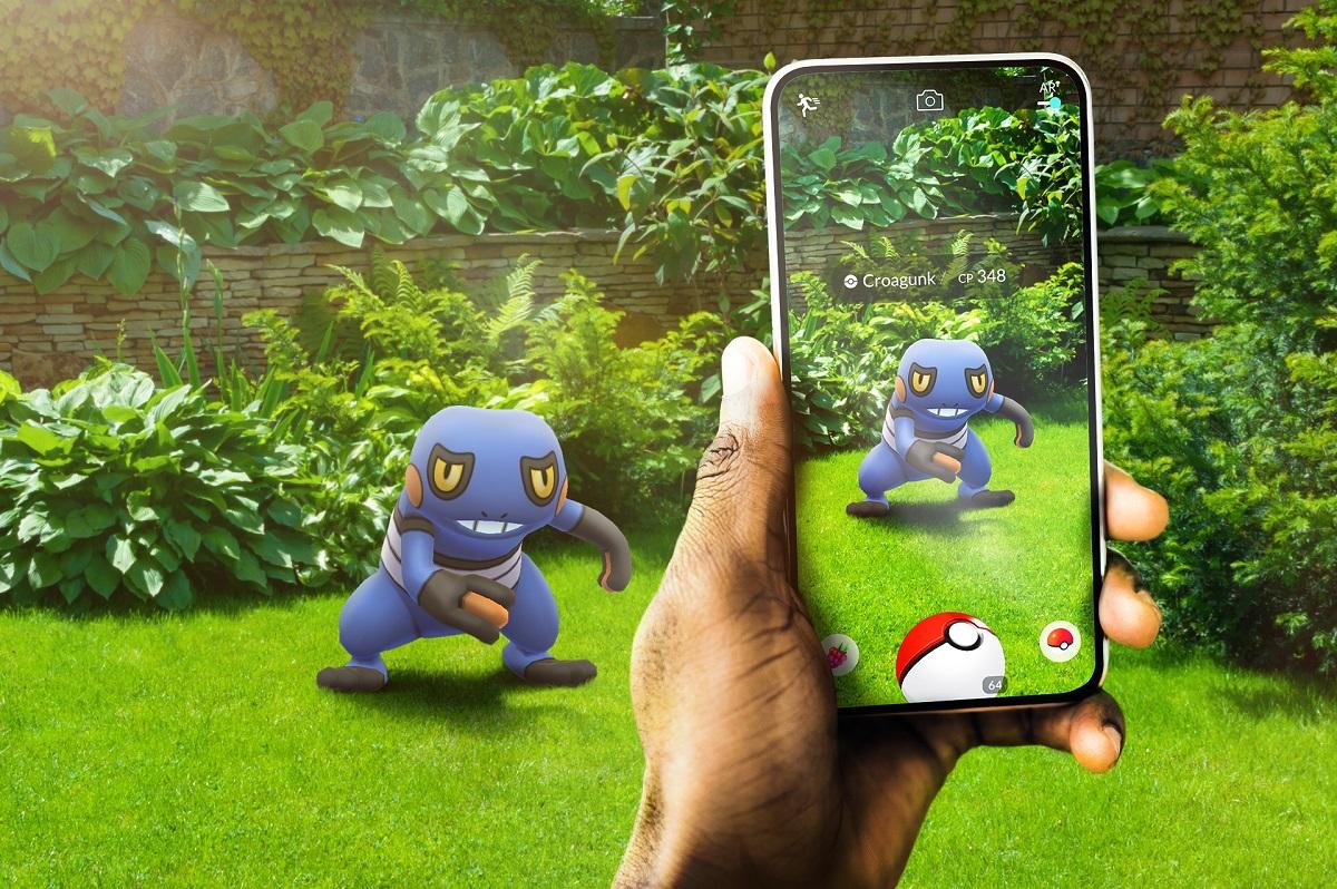 'Pokémon GO' Promo art of a Trainer battling a toad-like Pokémon.