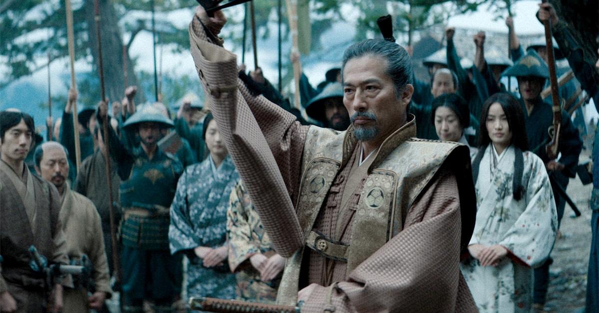 Hiroyuki Sanada holds a fan with the cast of 'Shōgun' behind him. 