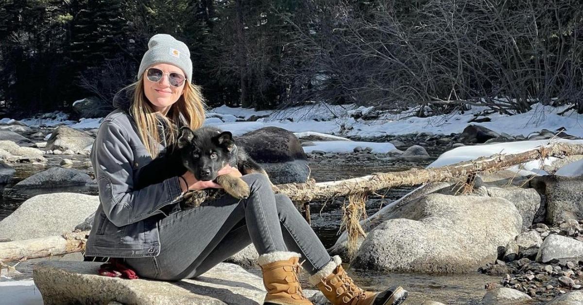 Kaiela Hobart outside on some rocks with her dog