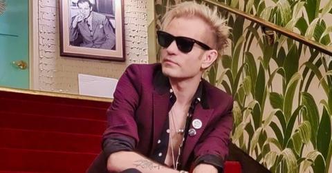 Deryck Whibley sits on red carpeted stairs
