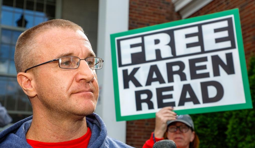 Aidan Kearney aka Turtleboy next to a sign that says "Free Karen Read"