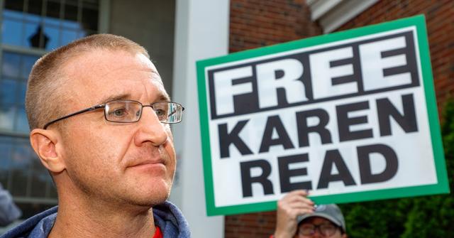 Aidan Kearney aka Turtleboy next to a sign that says "Free Karen Read"