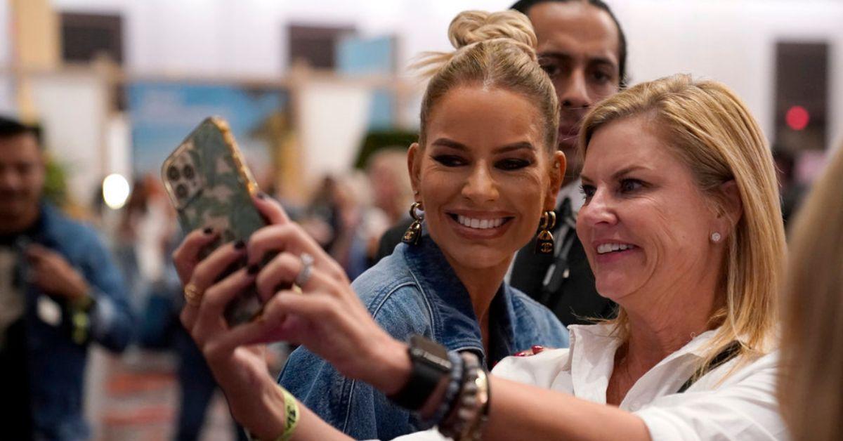 Caroline Stanbury poses for a photo with a fan at BravoCon2023