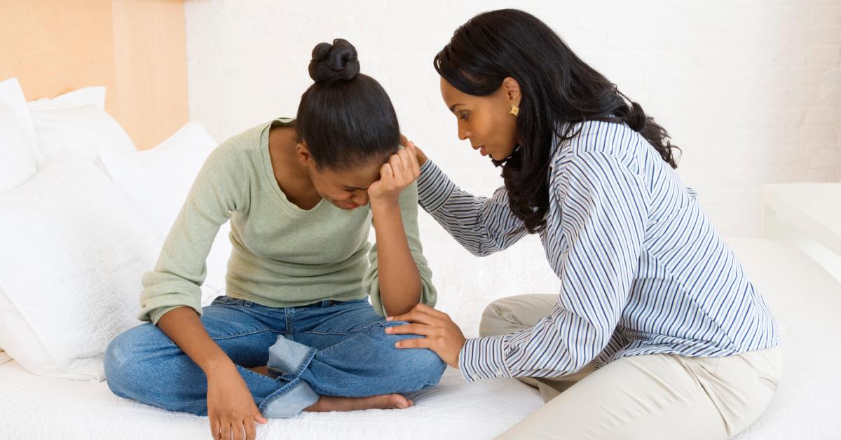 A mother consoles her crying teenage daughter.