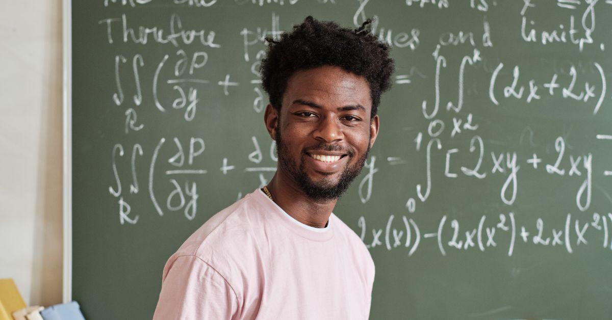 man next to chalkboard