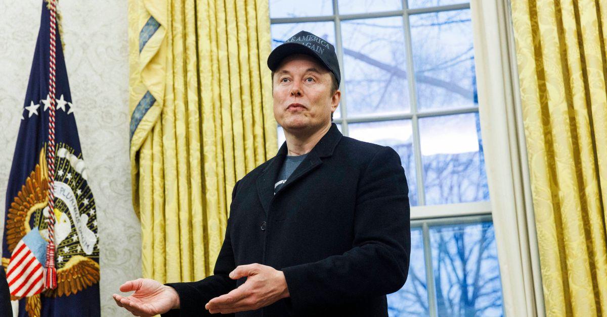 Elon Musk speaking in the Oval Office in a MAGA hat. 