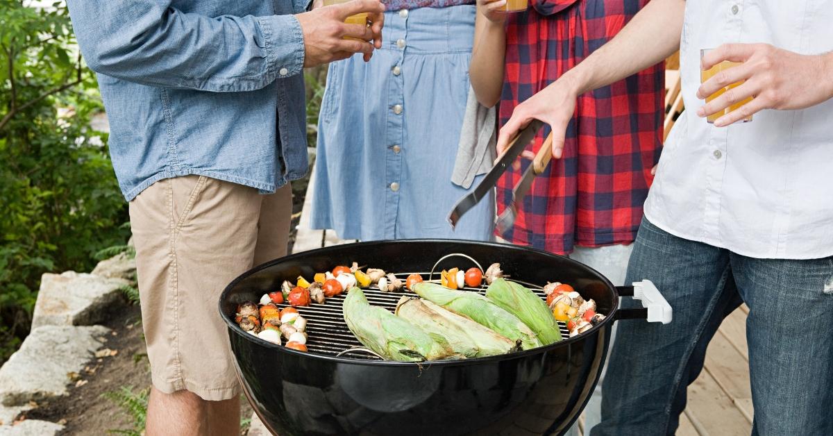 Four young people having a barbecue - stock photo