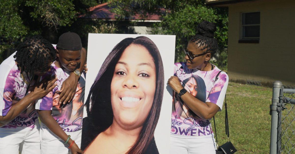 Loved ones of AJ Owens holding up a picture of her.