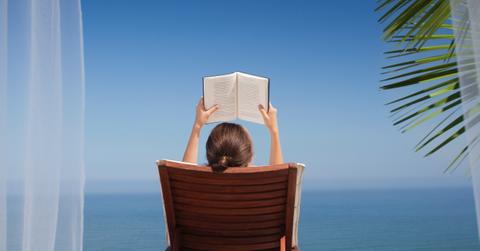 Person reading a book on vacation.